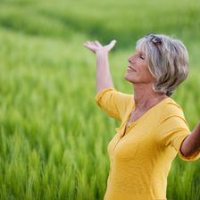 mature woman with outstretched arms in nature
